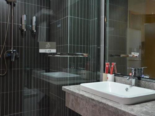 a bathroom with a sink and a shower at Thank Inn Chain Hotel henan luoyang mengjin county huimeng avenue bilingual school in Luoyang