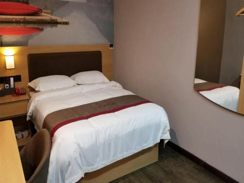 um quarto com uma cama grande e um espelho em Thank Inn Chain Hotel jiangxi ganzhou zhanggong district civilization avenue em Ganzhou