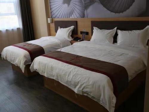 two beds in a hotel room with white sheets at Thank Inn Chain Hotel shandong binzhou bincheng district vocational college in Binzhou