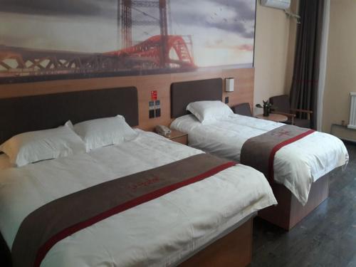 a hotel room with two beds and a painting on the wall at Thank Inn Chain Hotel Shandong Weifang Changle County Gem City in Weifang