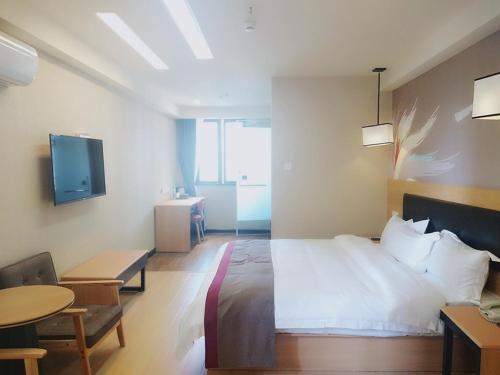 a bedroom with a bed and a table and a tv at Thank Inn Chain Hotel Chongqing nanan district tongjing international store in Chongqing