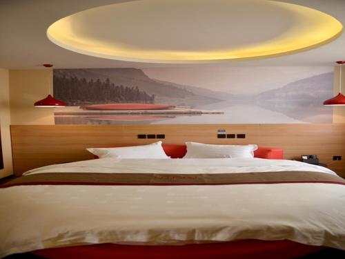 a bedroom with a large bed with a yellow ceiling at Thank Inn Chain Hotel Jiangsu xuzhou gulou DaHuangShan in Xuzhou