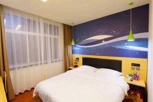 um quarto com uma cama e uma pintura de um barco em Thank Inn Chain Hotel henan jiaozuo liberated district democracy road em Jiaozuo