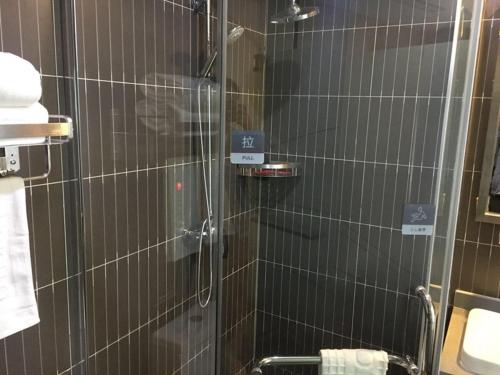 a shower with a glass door in a bathroom at Thank Inn Chain Hotel sichuan guang'an yuechi rongxinyue city in Guang'an
