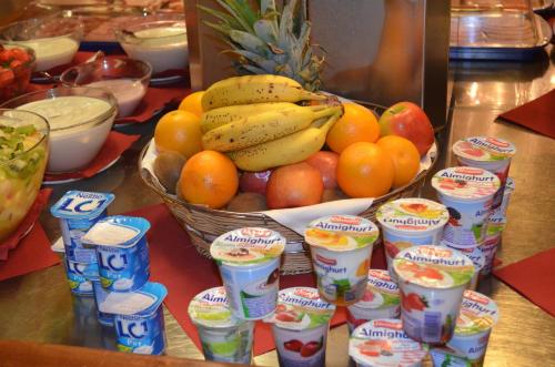 a bowl of fruit with a basket of bananas and oranges at Hotel Landhaus Milser in Duisburg