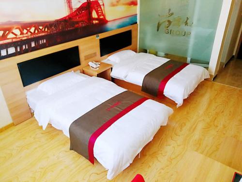 two beds in a hotel room at Thank Inn Chain Hotel hebei zhangjiakou wanquan county kongjiazhuang bus station in Zhangjiakou