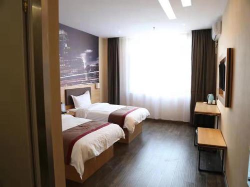 a hotel room with two beds and a window at Thank Inn Chain Hotel shandong binzhou bincheng district vocational college in Binzhou