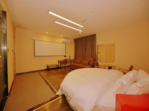 a bedroom with a large white bed and a projection screen at Thank Inn Chain Hotel sichuan ziyang yanjiang district walmart in Ziyang