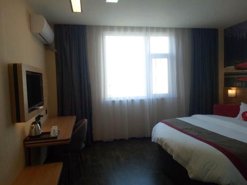 a hotel room with a bed and a window at Thank Inn Chain Hotel shandong binzhou bincheng district binbei in Binzhou