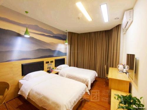 um quarto de hotel com duas camas e um quadro na parede em Thank Inn Chain Hotel henan jiaozuo liberated district democracy road em Jiaozuo