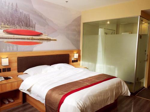 um quarto com uma cama grande e um quadro na parede em Thank Inn Chain Hotel shandong heze juye county shanghai jiayuan em Heze
