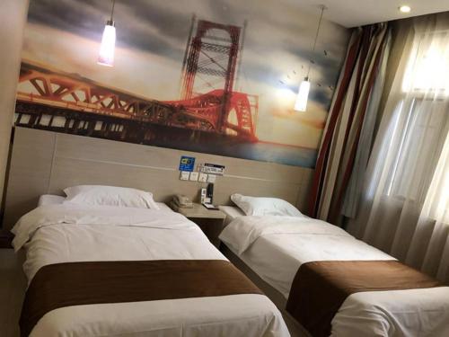 BinzhouにあるThank Inn Chain Hotel Shandong Binzhou Bohai 5th Roadのベッド2台が備わる客室で、壁にクレーンが付いています。