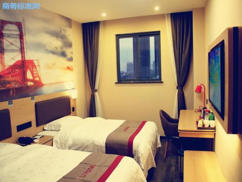 a hotel room with two beds and a desk and a window at Thank Inn Chain Hotel shanxi xianyang sanyuan county yuyuan road in Xianyang