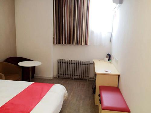 a hotel room with a bed and a desk and a window at Thank Inn Chain Hotel shandong yantai high-speed railway sounth station in Yantai