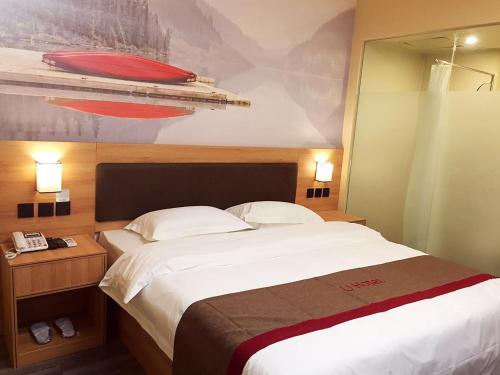 um quarto com uma cama e uma fotografia de um barco em Thank Inn Chain Hotel shandong heze juye county shanghai jiayuan em Heze