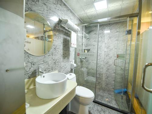 a bathroom with a toilet and a glass shower at Thank Inn Chain Hotel guangdong shenzhen airport hourui metro station in Shenzhen
