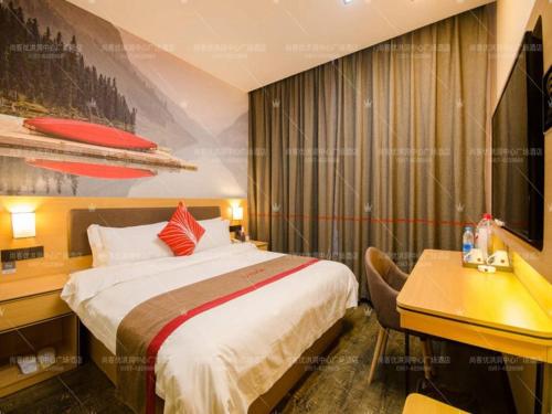 a hotel room with a bed and a desk and a desk at Thank Inn Chain Hotel Shanxi Linfen Central square of Hongtong county in Linfen
