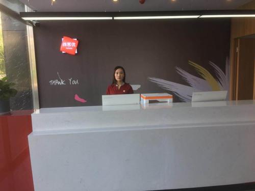 a woman standing behind a counter in a room at Thank Inn Chain Hotel hebei handan wei county tian'an avenue chinese medicine hospital in Handan