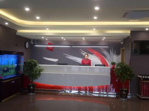 a woman standing in front of a stage in a room at Thank Inn Chain Hotel shandong binzhou bincheng district binbei in Binzhou