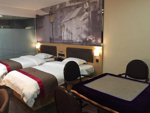 a room with three beds with chairs and a painting at Thank Inn Chain Hotel guizhou zunyi chishui city red army avenue jinshui bay in Chishui