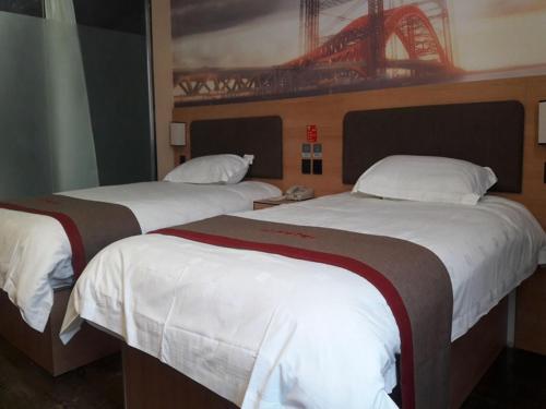 two beds in a hotel room with a bridge on the wall at Thank Inn Chain Hotel Shandong Weifang Changle County Gem City in Weifang