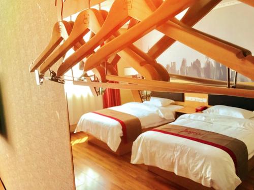 Duas camas num quarto com tecto em madeira em Thank Inn Chain Hotel tibet shigatse angren county government em Kaika