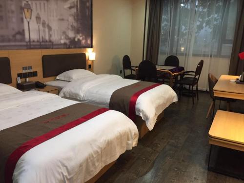 a hotel room with two beds and a table and chairs at Thank Inn Chain Hotel guizhou zunyi chishui city red army avenue jinshui bay in Chishui