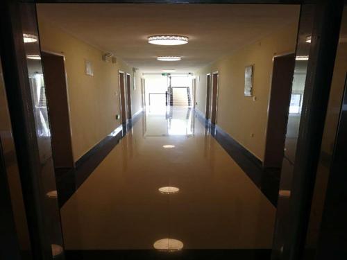 an empty hallway of a building with doors and a hallwayngth at Thank Inn Chain Hotel henan kaifeng longting district henan university north gate in Kaifeng