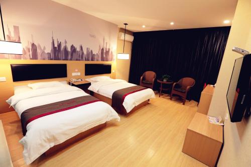 um quarto de hotel com duas camas e uma mesa em Thank Inn Chain Hotel shanxi weinan linwei district jiefang road em Weinan