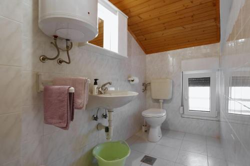 a bathroom with a sink and a toilet and a window at Little Heaven on Earth - Apartmani Martina in Vlašići