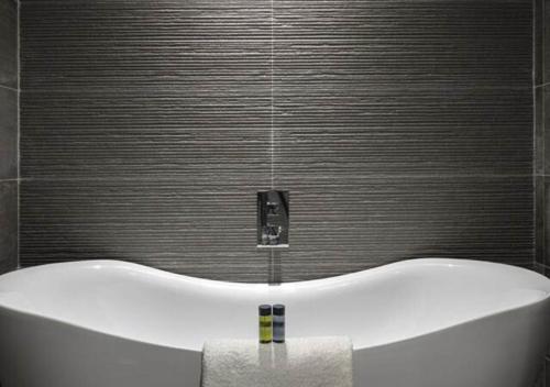 een badkamer met een bad en een zwarte muur bij Bayview Hotel in Ballycotton