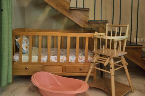a wooden crib with a chair and a staircase at Vacaciones Aregua CASA VANESSA in Areguá