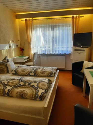 バート・ケーニヒにあるホテル アイリーンのベッド2台と窓が備わるホテルルームです。