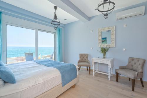 1 dormitorio con cama y vistas al océano en Celestine Suites en Kolymvari