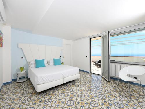 アマルフィにあるホテル ヴィラ フェリーチェ ルレの白いベッドが備わるベッドルーム1室から海の景色を望めます。