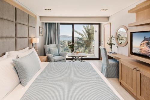 a hotel room with a bed and a television at Elounda Bay Palace, a Member of the Leading Hotels of the World in Elounda