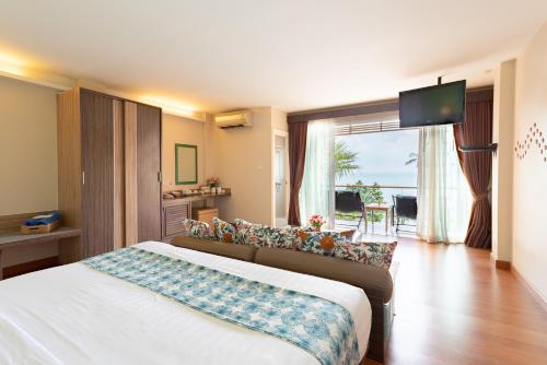 a hotel room with a bed and a television at Palm Coco Mantra in Lamai