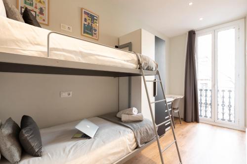 מיטה או מיטות קומותיים בחדר ב-Aspasios Urquinaona Design