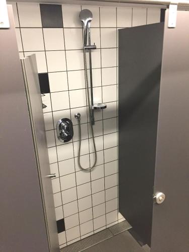 a shower in a bathroom with a tile wall at Safestay Barcelona Gothic in Barcelona