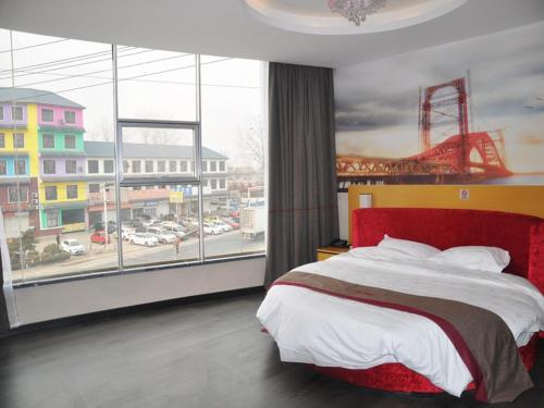 1 dormitorio con cama roja y ventana grande en Thank Inn Chain Hotel Shandong linyi hedong hot spring resort, en Linyi