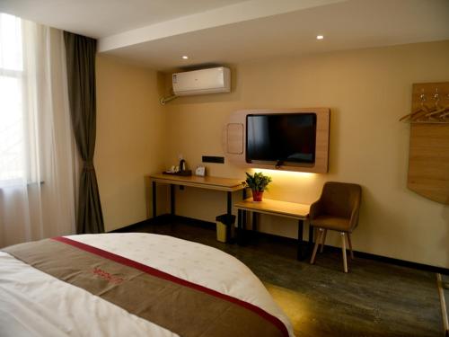 a hotel room with a bed and a desk and a television at Thank Inn Chain Hotel Jiangsu xuzhou gulou DaHuangShan in Xuzhou