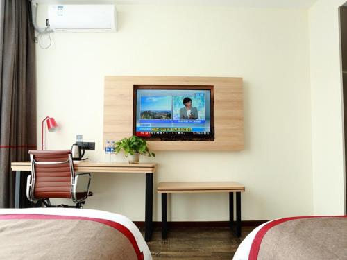 a room with a desk with a television on a wall at Thank Inn Chain Hotel Jiangsu nantong tongzhou district XianFeng Town KaiHao square in Nantong