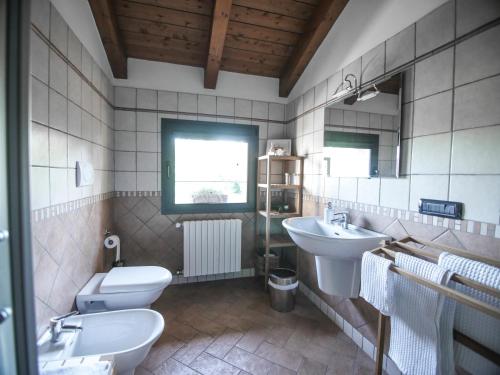 ein Badezimmer mit zwei Waschbecken, einem WC und einem Spiegel in der Unterkunft Quattrocolli B&B in Quattro Castella