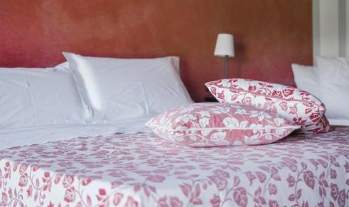 a bed with red and white pillows on it at Quattrocolli B&B in Quattro Castella