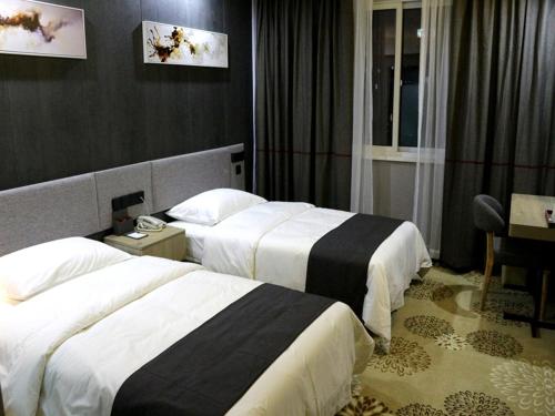 a hotel room with two beds and a desk at Thank Inn Plus Hotel Jiangsu huaian huaiyin area of the Yangtze river east road in Huai'an