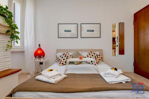 1 dormitorio con 1 cama con toallas en DesenzanoLoft Porto Vecchio, en Desenzano del Garda