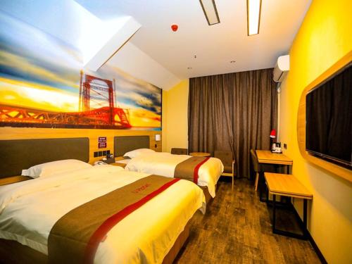 a hotel room with two beds and a tv at Thank Inn Chain Hotel Jiangsu Yancheng dongtai Jianggang town in Cuiguangshan