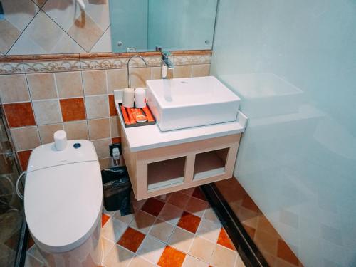 a bathroom with a white sink and a toilet at Thank Inn Chain Hotel Jiangsu yancheng pavilion lakes open road in Yancheng