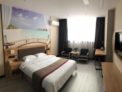a hotel room with a bed and a painting on the wall at Thank Inn Chain Hotel hebei handan wei county tian'an avenue chinese medicine hospital in Handan