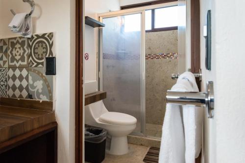 a bathroom with a toilet, sink and shower at Villas Palmar Holbox in Holbox Island